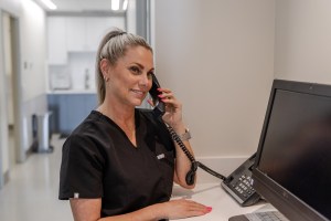Image of a smiling staff member answering a phone